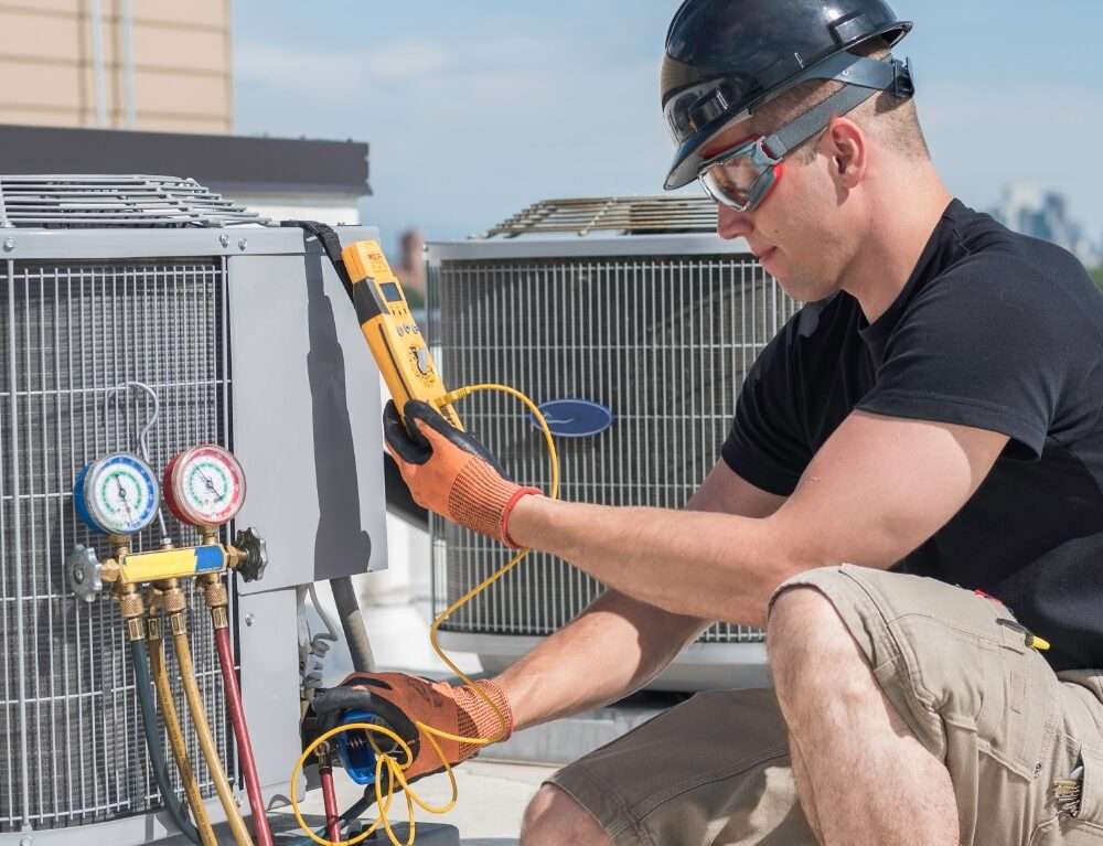 a technician male checking the pressure of an ac compressor gas