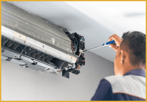 a technician opening an ac board with a screw on a wall